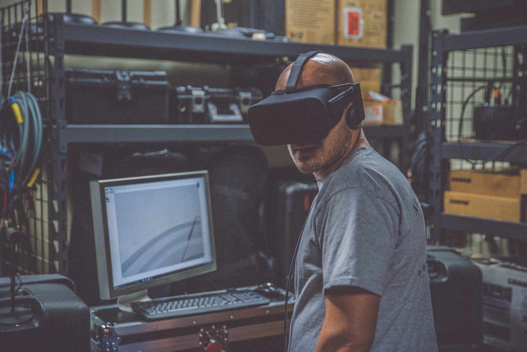 Mann in einem Technikkeller und VR Brille auf schaut sich um