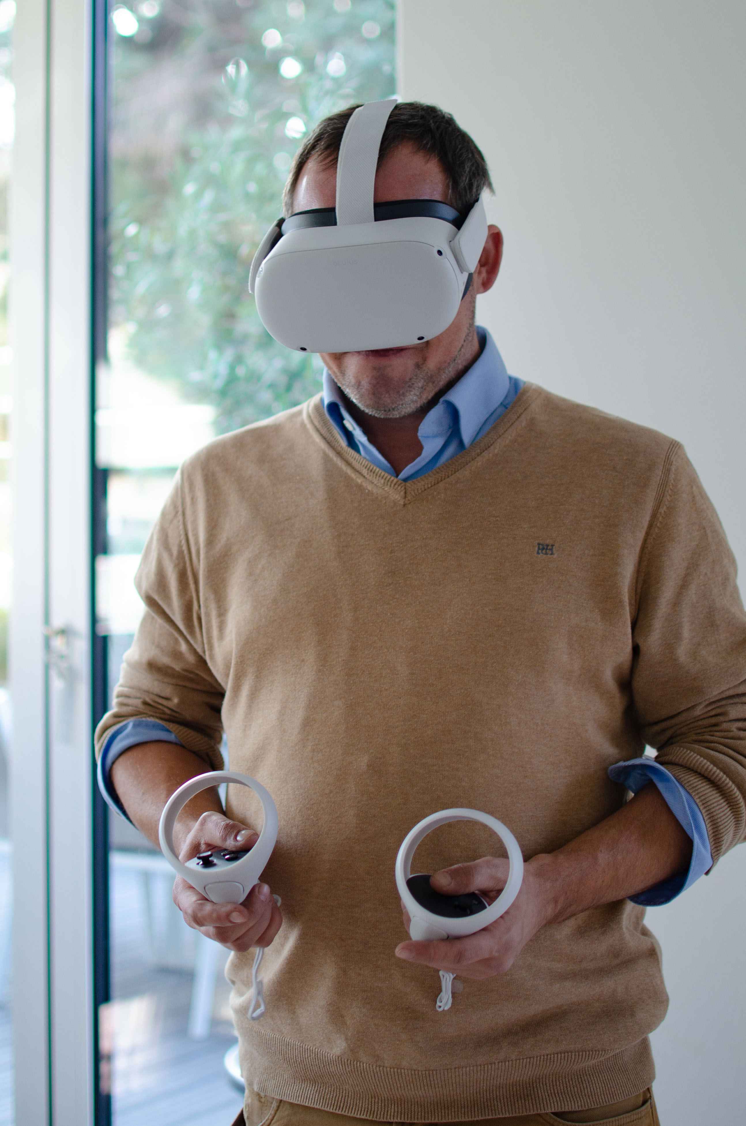 Man with a VR headset on and two VR controllers in hand