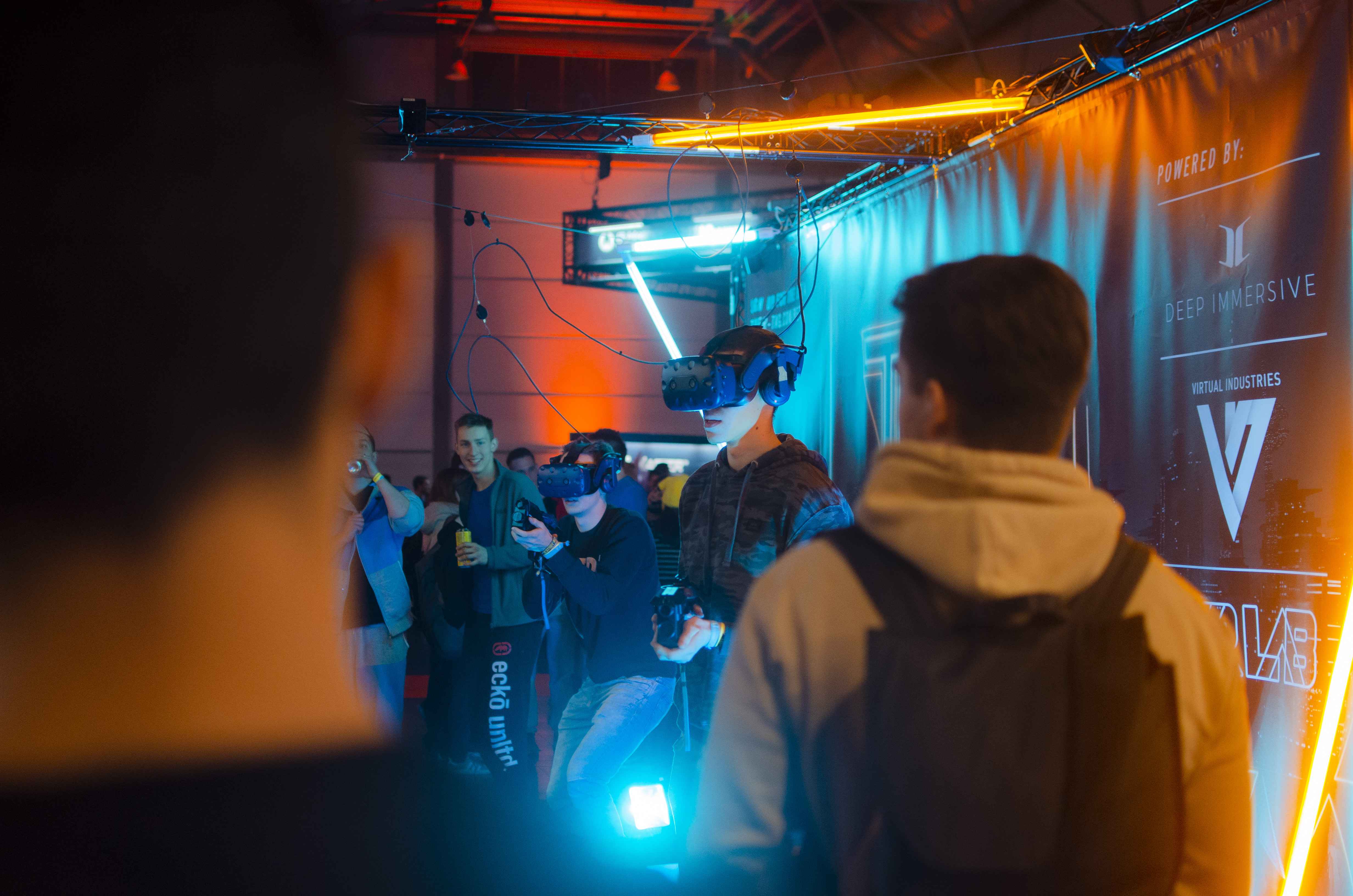 Mehrere Menschen bedienen einen Kicker und haben VR-Brillen auf